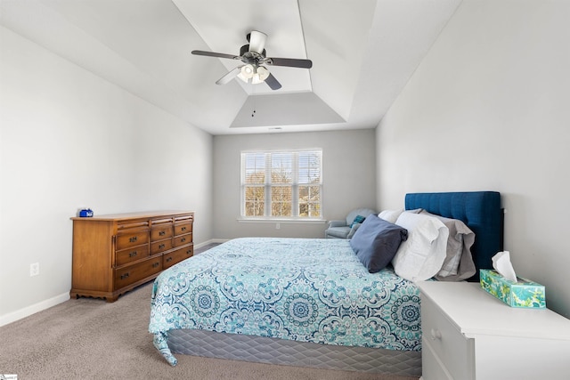 carpeted bedroom featuring baseboards, a tray ceiling, and ceiling fan