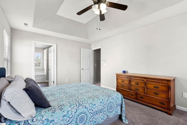 carpeted bedroom with baseboards, visible vents, a ceiling fan, a raised ceiling, and connected bathroom