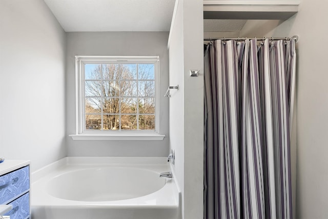 bathroom featuring a textured ceiling, a shower with shower curtain, a garden tub, and vanity