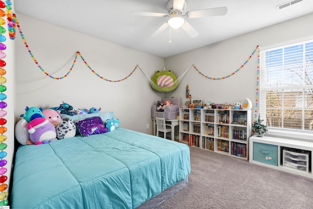 bedroom featuring a ceiling fan, visible vents, and carpet flooring