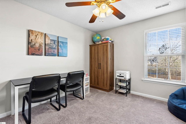 office space featuring plenty of natural light, visible vents, baseboards, and light colored carpet