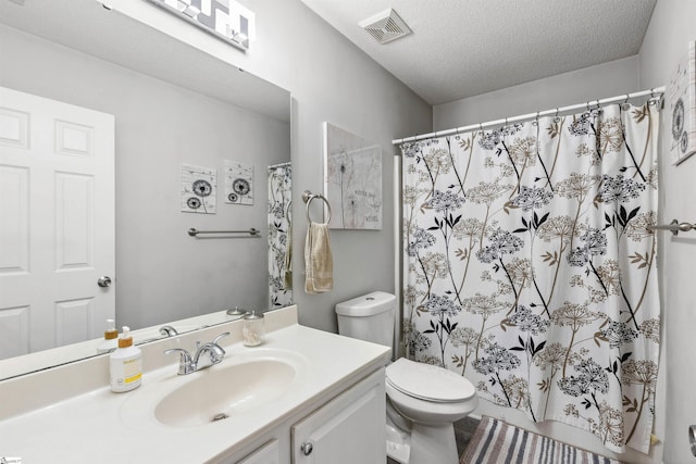 bathroom featuring curtained shower, visible vents, toilet, a textured ceiling, and vanity