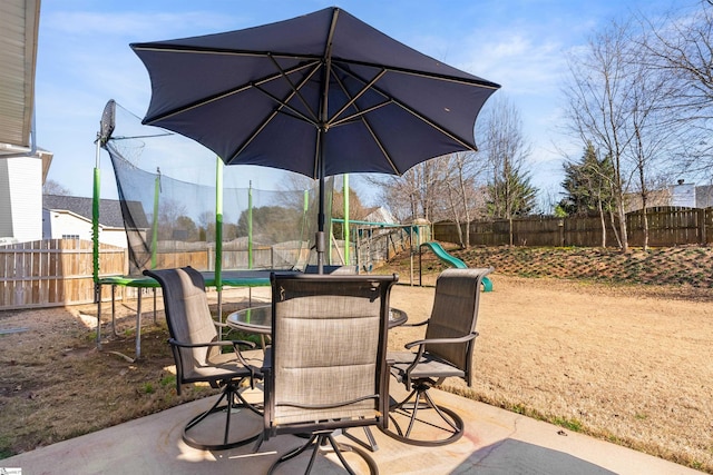 view of patio featuring a fenced backyard, outdoor dining area, and a playground