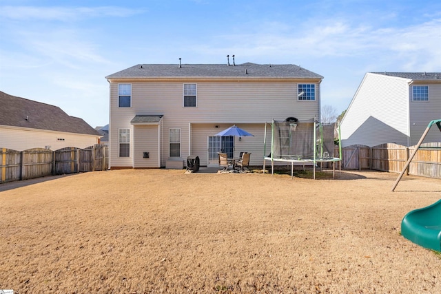 back of house featuring a fenced backyard, a trampoline, a gate, and a patio