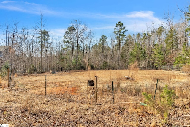 view of yard featuring fence and a view of trees