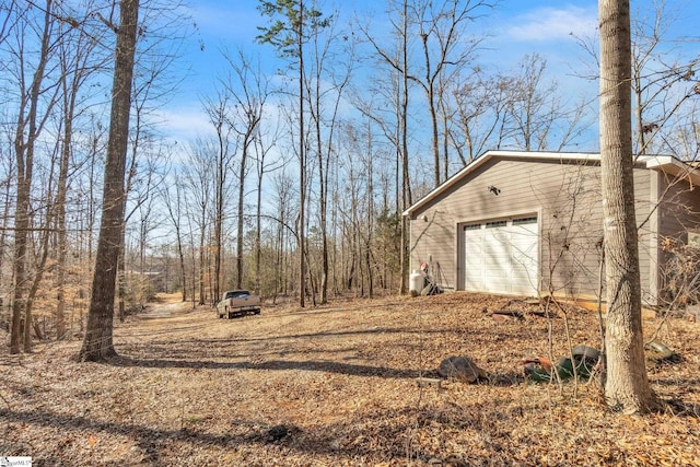 view of yard featuring a garage and driveway