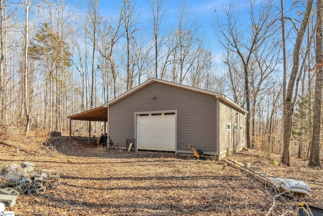 detached garage featuring a carport and driveway