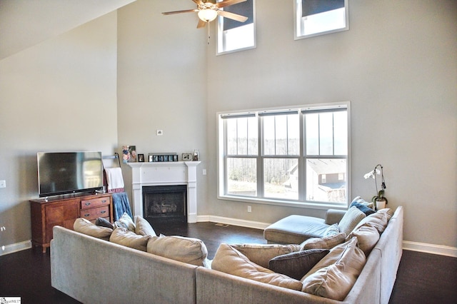 living room featuring a wealth of natural light, dark wood-style flooring, and a fireplace