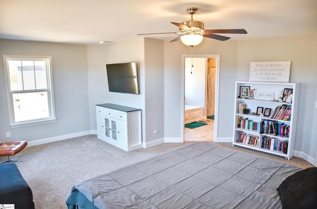 carpeted bedroom featuring ceiling fan, ensuite bath, and baseboards