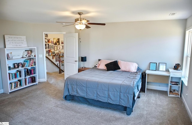 carpeted bedroom featuring baseboards, visible vents, and a ceiling fan