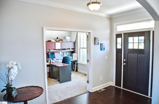 foyer with baseboards, visible vents, arched walkways, wood finished floors, and crown molding