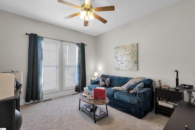 living area with carpet, visible vents, and a ceiling fan