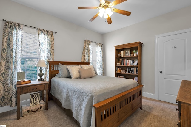 carpeted bedroom with a ceiling fan and baseboards