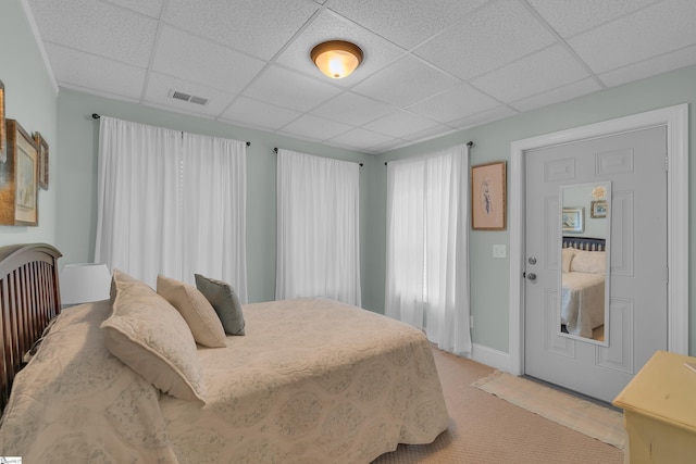 bedroom featuring visible vents, carpet, and a paneled ceiling