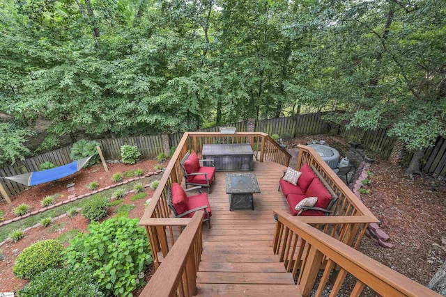 deck featuring an outdoor living space with a fire pit and a fenced backyard