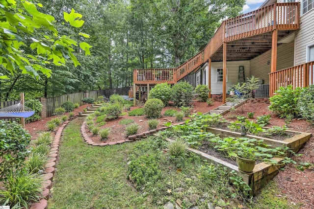 view of yard featuring stairway, fence, a vegetable garden, and a deck