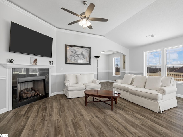 living room with arched walkways, a fireplace, lofted ceiling, wood finished floors, and baseboards