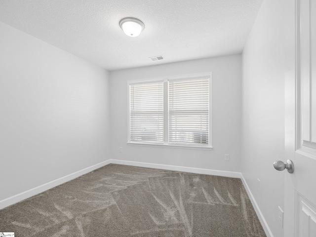 unfurnished room featuring carpet, a textured ceiling, visible vents, and baseboards