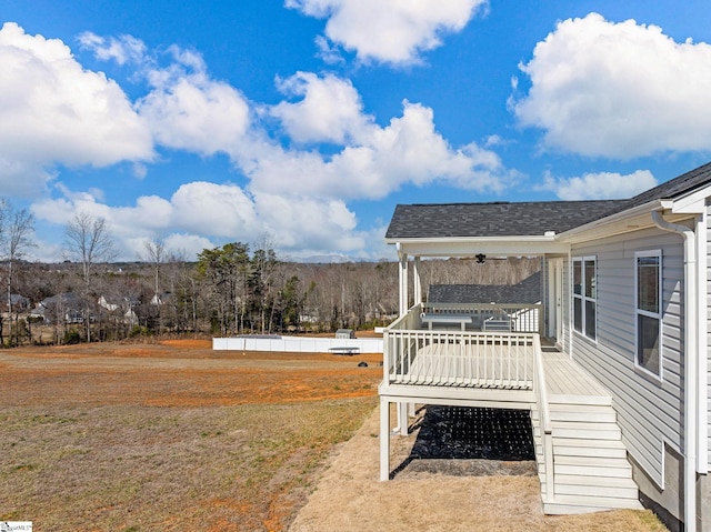 view of yard featuring a deck, stairway, and a ceiling fan