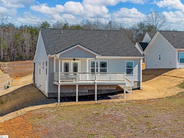 view of front of home featuring a deck, ceiling fan, and roof with shingles