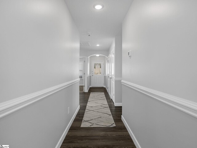 hall with arched walkways, recessed lighting, visible vents, wood finished floors, and baseboards