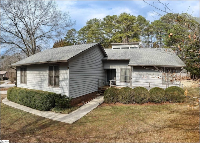 view of front of property with a front yard and roof with shingles