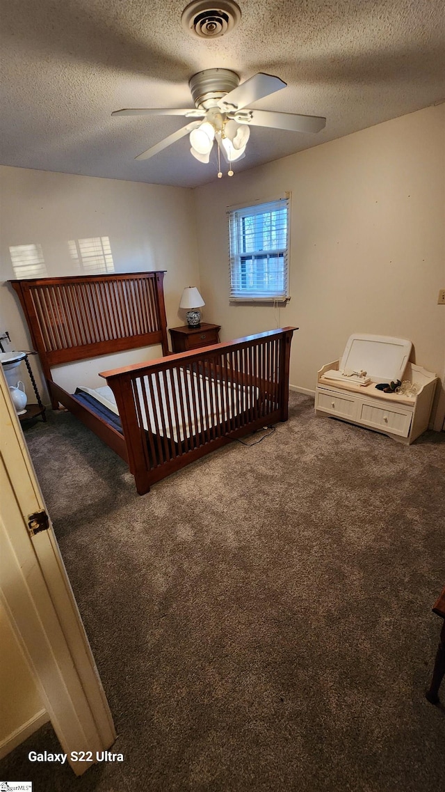 bedroom with carpet flooring, ceiling fan, visible vents, and a textured ceiling