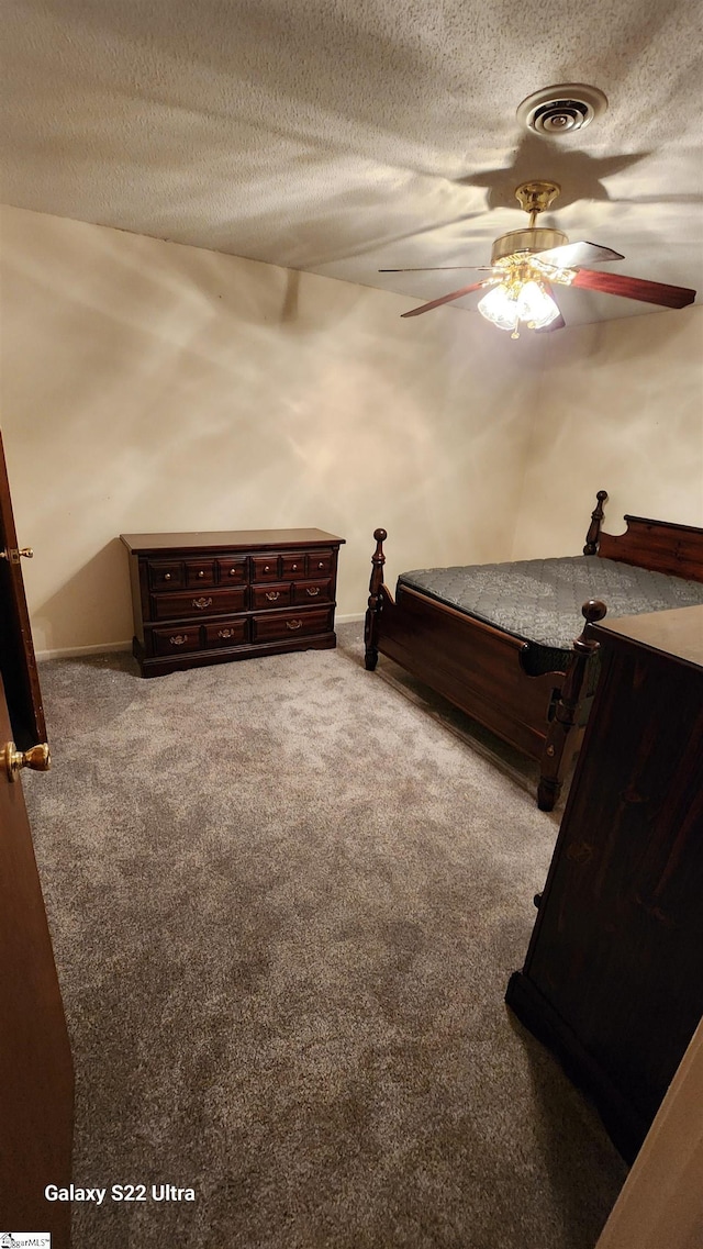 bedroom with a ceiling fan, carpet, visible vents, and a textured ceiling