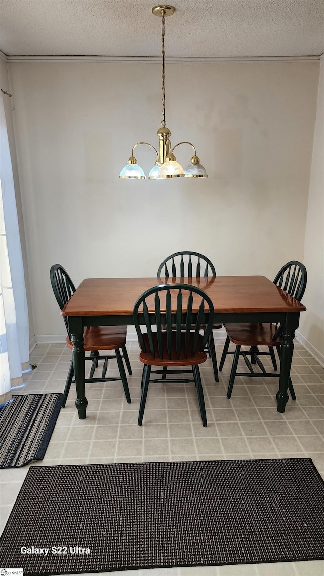 dining area with a chandelier, light tile patterned flooring, a textured ceiling, and baseboards