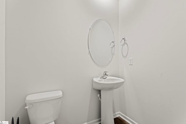 bathroom with baseboards and toilet