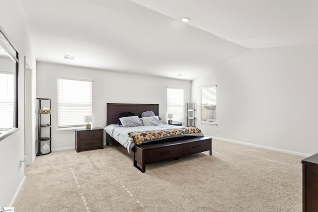 carpeted bedroom with lofted ceiling, visible vents, baseboards, and multiple windows