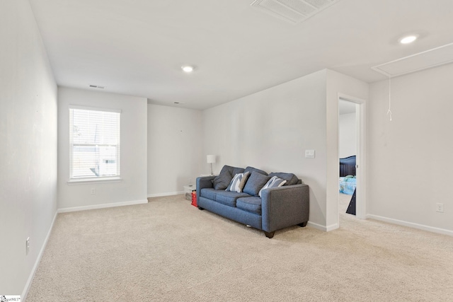 living room featuring carpet, attic access, visible vents, and baseboards