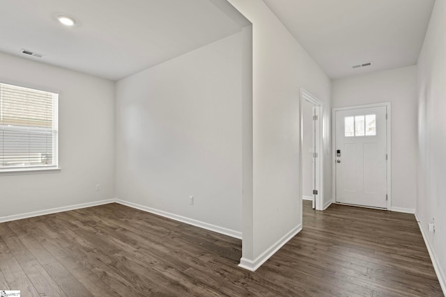 foyer entrance featuring dark wood-type flooring, visible vents, and baseboards