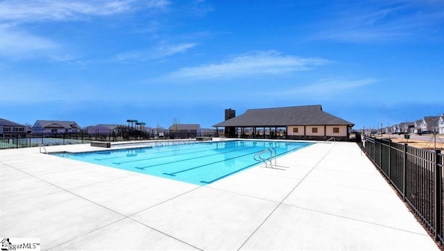 community pool with fence and a patio