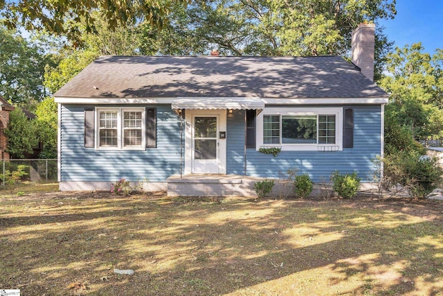 bungalow-style home with fence and a chimney