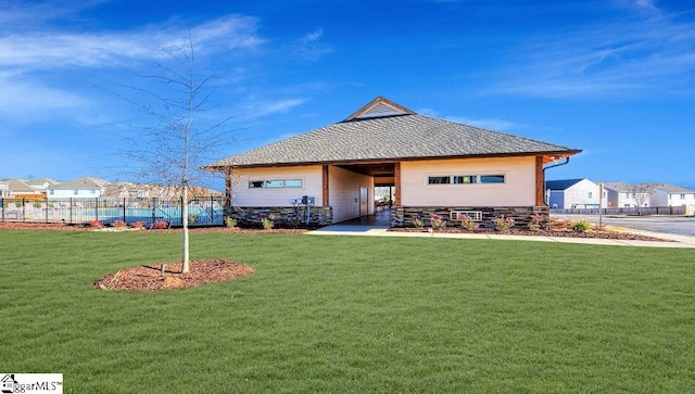 view of front facade with a front lawn, fence, and a residential view