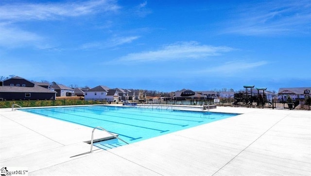 pool with a residential view, fence, and a patio