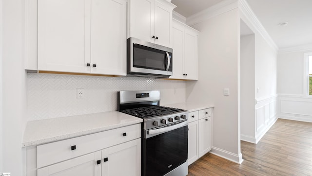1791 Wabash Pl Lot 0511, Boiling Springs, SC 29316 - kitchen featuring appliances with stainless steel finishes, crown molding, decorative backsplash, light wood-type flooring, and white cabinets