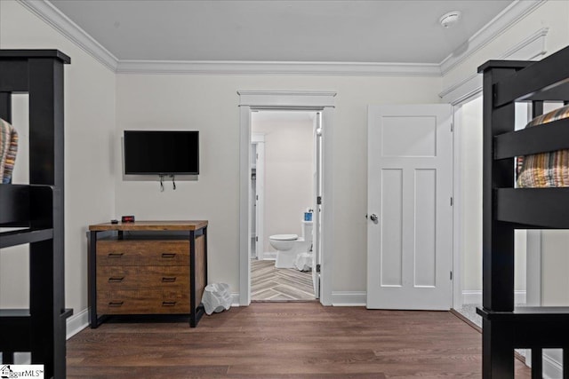 bedroom with ornamental molding, baseboards, and wood finished floors