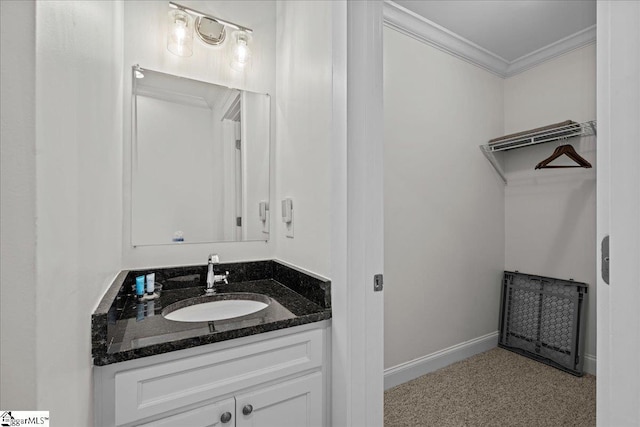 bathroom with baseboards, crown molding, and vanity