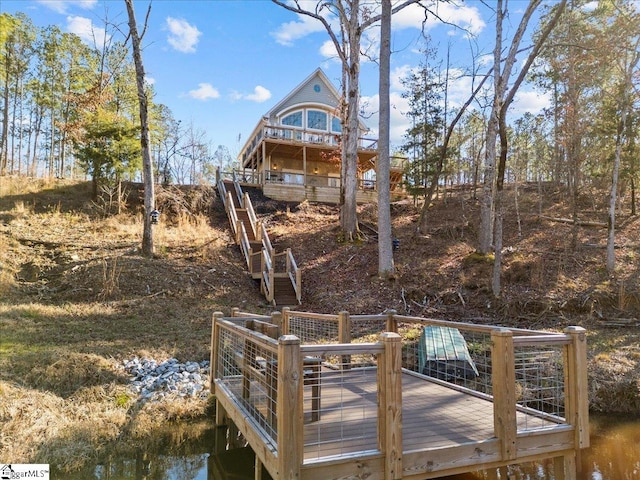 view of dock with stairway and a wooden deck