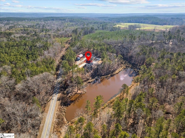 aerial view featuring a water view and a wooded view