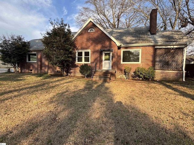 view of front facade featuring a front yard, brick siding, a chimney, and roof with shingles