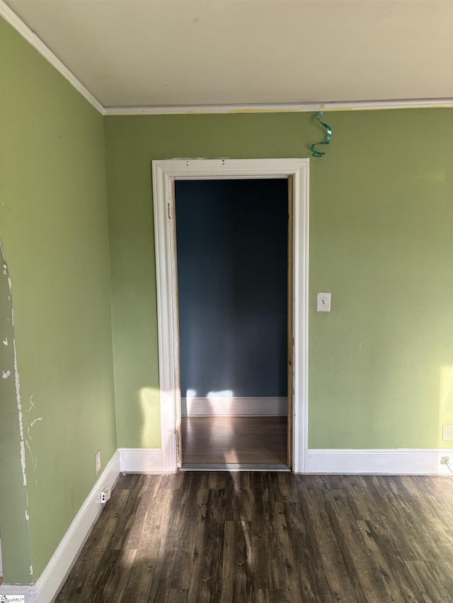 unfurnished room with crown molding, baseboards, and wood finished floors