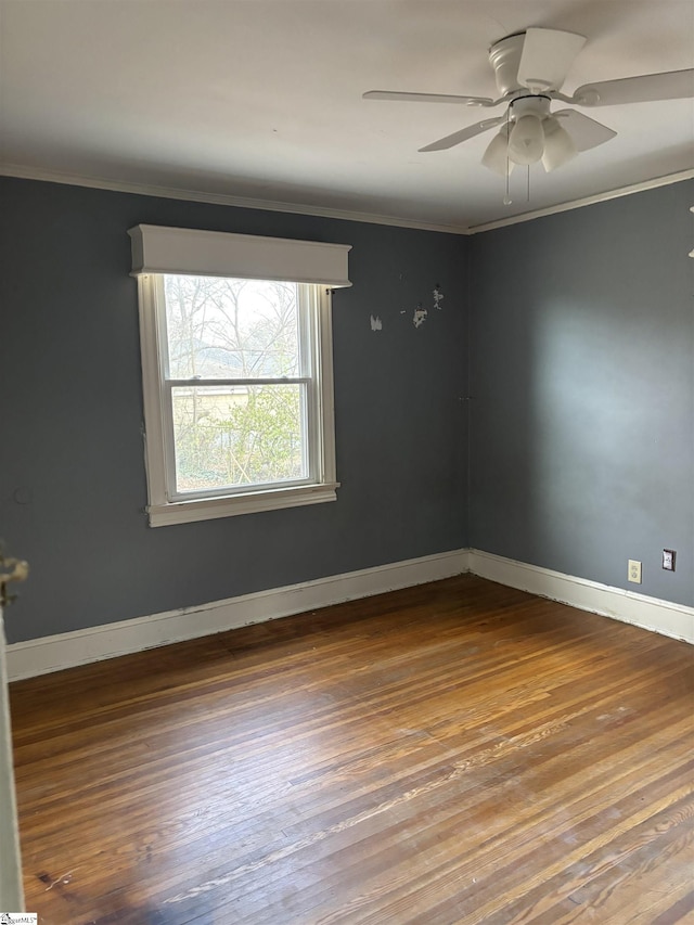 unfurnished room featuring baseboards, crown molding, and wood finished floors