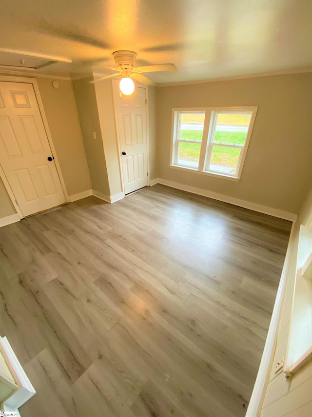 unfurnished bedroom with a ceiling fan, baseboards, and wood finished floors