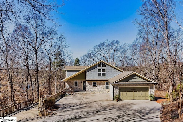 view of front of house with a garage, stone siding, and concrete driveway