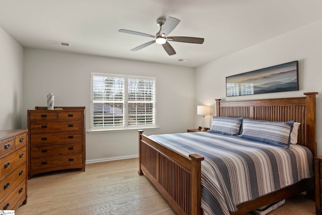 bedroom with ceiling fan, light wood finished floors, visible vents, and baseboards