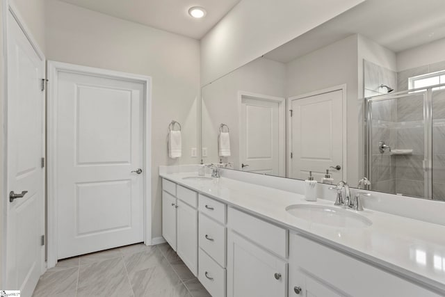 full bathroom with double vanity, a shower stall, and a sink