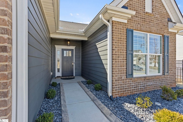 entrance to property featuring brick siding